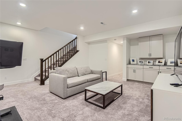 carpeted living room featuring washer / dryer