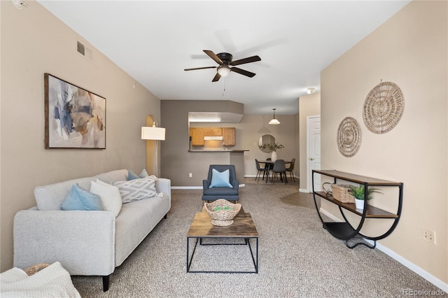 living area with visible vents, baseboards, ceiling fan, and carpet floors
