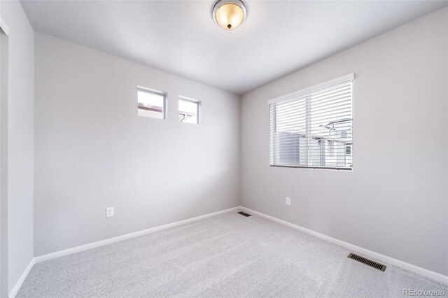 carpeted spare room featuring baseboards