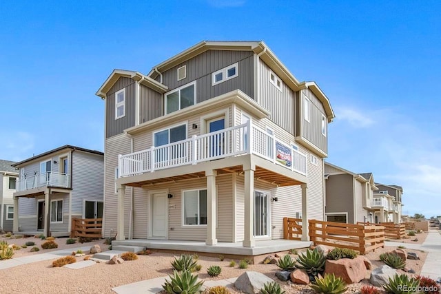view of front of property with board and batten siding, a balcony, and covered porch