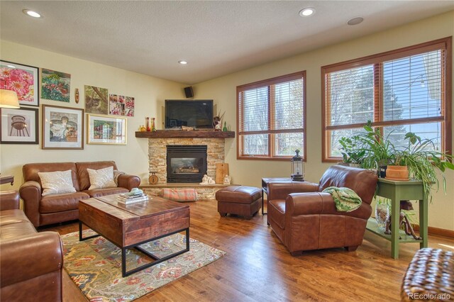 living area featuring recessed lighting, wood finished floors, and a fireplace