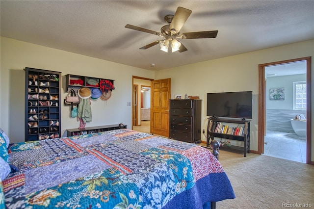 carpeted bedroom featuring a ceiling fan and ensuite bathroom
