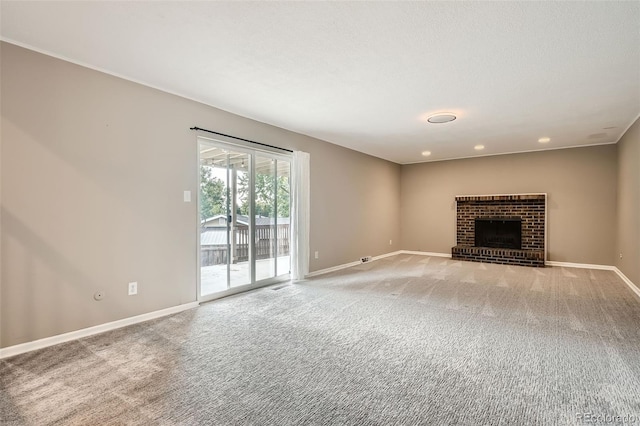 unfurnished living room with a brick fireplace, a textured ceiling, and carpet flooring