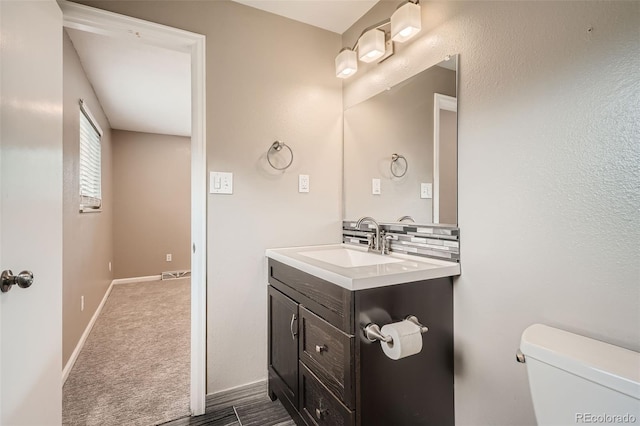 bathroom featuring tasteful backsplash, vanity, and toilet