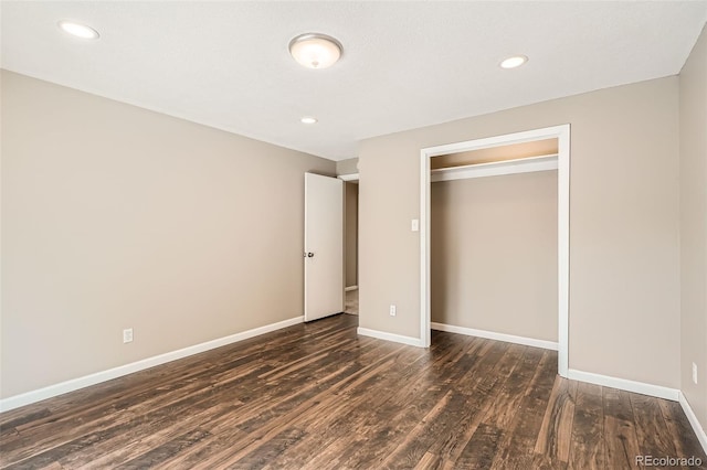 unfurnished bedroom featuring dark wood-type flooring and a closet