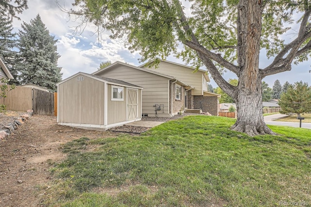 back of property with a storage shed and a yard