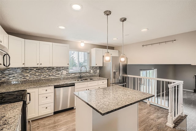 kitchen featuring sink, white cabinets, hanging light fixtures, a center island, and stainless steel appliances