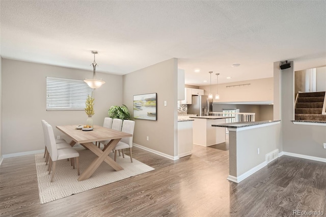 dining area featuring a textured ceiling and dark hardwood / wood-style flooring