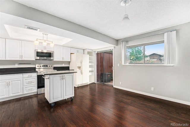 kitchen featuring stainless steel appliances, baseboards, white cabinets, a kitchen island, and pendant lighting