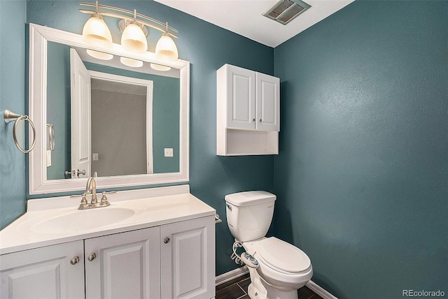 half bath featuring toilet, baseboards, and vanity