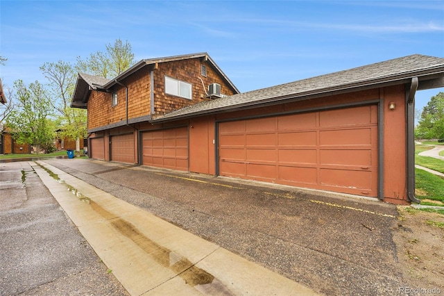 garage featuring asphalt driveway and central AC