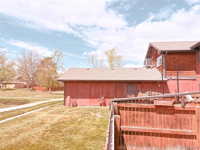 rear view of house with a lawn and a shingled roof