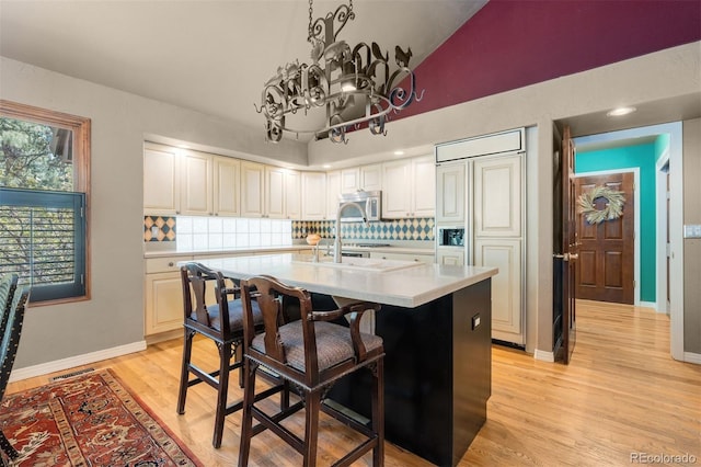 474 Silbrico Way, Castle Rock, CO 80108 - kitchen featuring stainless steel microwave, light countertops, backsplash, an island with sink, and high vaulted ceiling