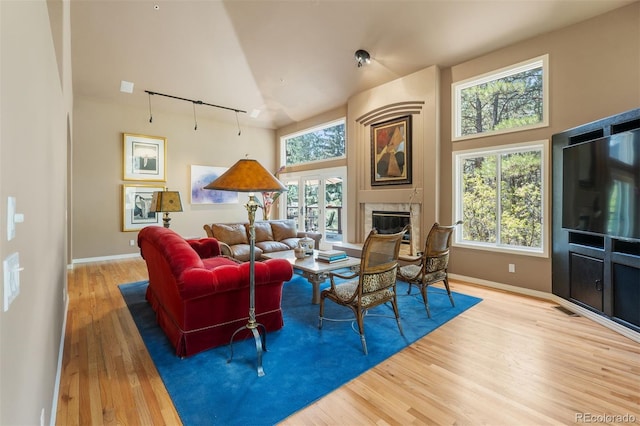 474 Silbrico Way, Castle Rock, CO 80108 - living area with wood finished floors, a glass covered fireplace, baseboards, and a high ceiling