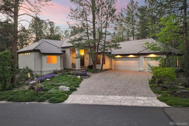 474 Silbrico Way, Castle Rock, CO 80108 - view of front of property featuring a tile roof, decorative driveway, stucco siding, and an attached garage