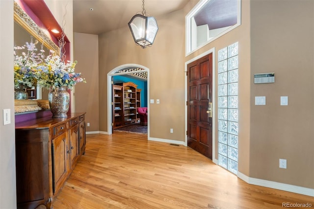 474 Silbrico Way, Castle Rock, CO 80108 - foyer featuring light wood-style flooring, a high ceiling, and arched walkways