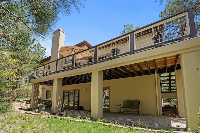 474 Silbrico Way, Castle Rock, CO 80108 - back of house featuring stucco siding, a patio, a balcony, and a chimney