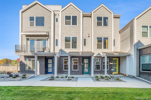 view of property featuring a front lawn and a balcony