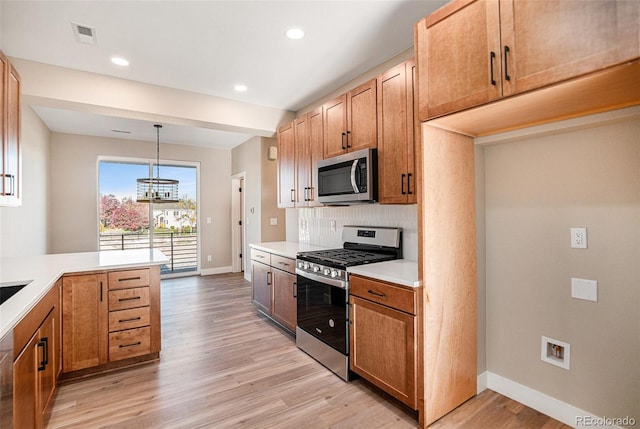 kitchen featuring light hardwood / wood-style floors, an inviting chandelier, hanging light fixtures, backsplash, and appliances with stainless steel finishes