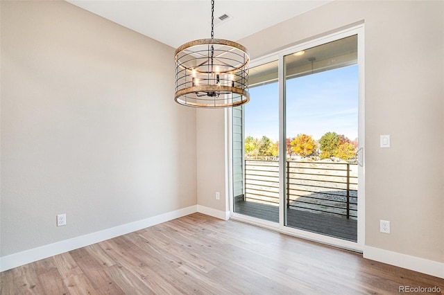 empty room with a chandelier and hardwood / wood-style floors