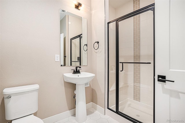 bathroom with a shower with door, tile patterned flooring, and toilet