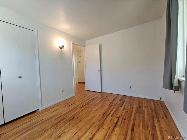 unfurnished bedroom featuring light hardwood / wood-style floors and a closet