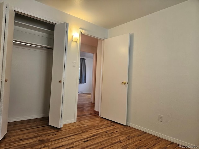 unfurnished bedroom featuring dark wood-type flooring and a closet