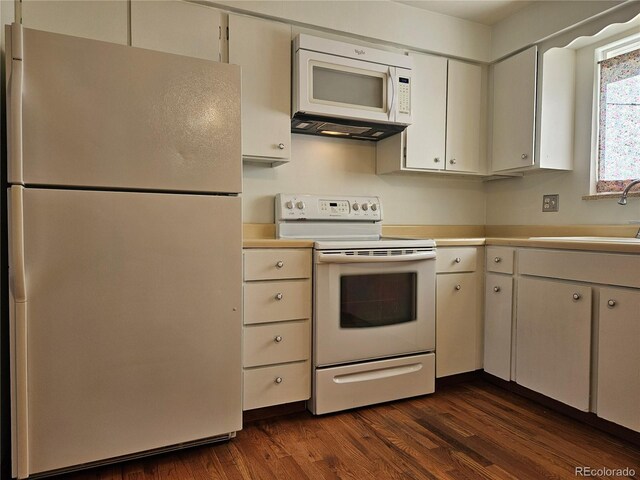 kitchen with white cabinetry, sink, white appliances, and dark wood-type flooring