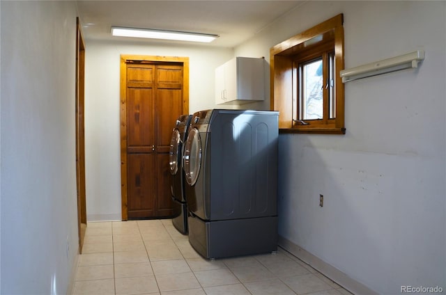 laundry area with cabinets, washer and dryer, and light tile patterned flooring