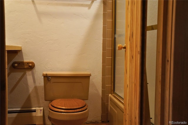 bathroom featuring a shower with door, a baseboard radiator, and toilet