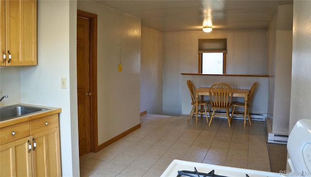 tiled dining room with a baseboard radiator and sink