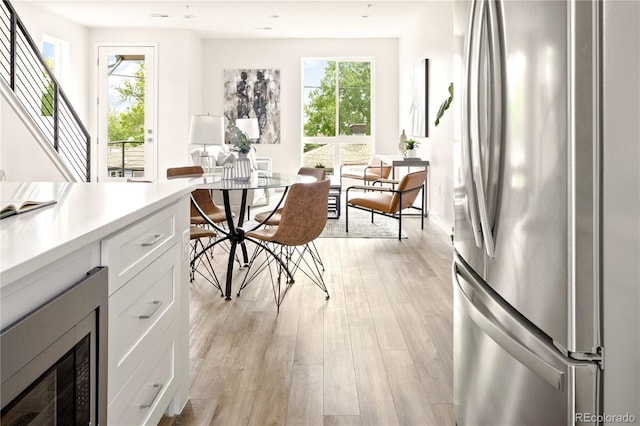 dining space with a healthy amount of sunlight and light hardwood / wood-style flooring