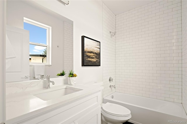 full bathroom with vanity, tiled shower / bath, and toilet