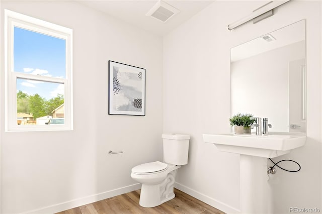 bathroom featuring wood-type flooring and toilet