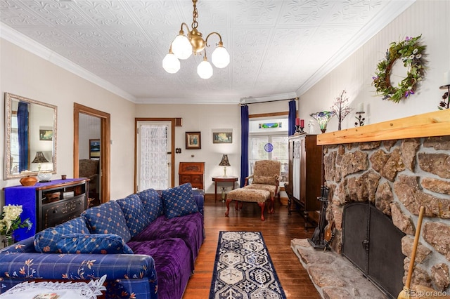 living area with a notable chandelier, ornamental molding, an ornate ceiling, wood finished floors, and a stone fireplace