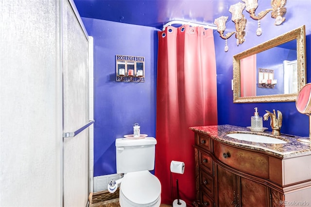 bathroom featuring toilet, walk in shower, and vanity