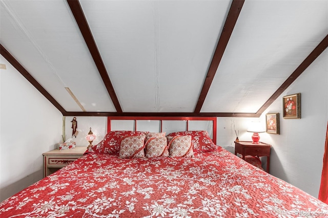 bedroom featuring vaulted ceiling with beams