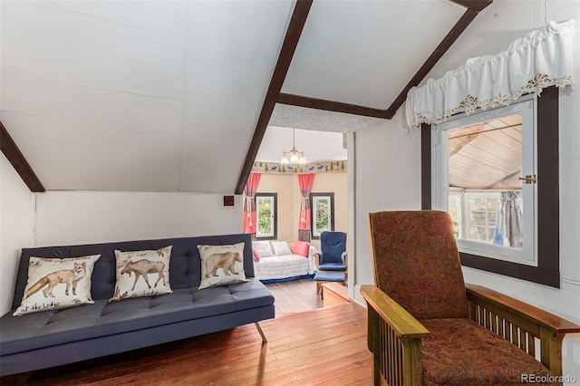 living area with lofted ceiling with beams and wood-type flooring