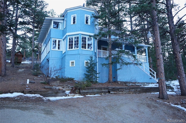 view of front of property featuring a balcony and stairway