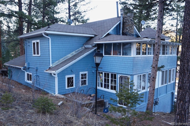 56216 US Highway 285, Shawnee, CO 80475 - rear view of property featuring a sunroom, a shingled roof, and a chimney