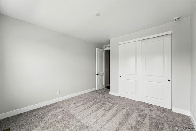 unfurnished bedroom featuring carpet flooring, baseboards, and a closet