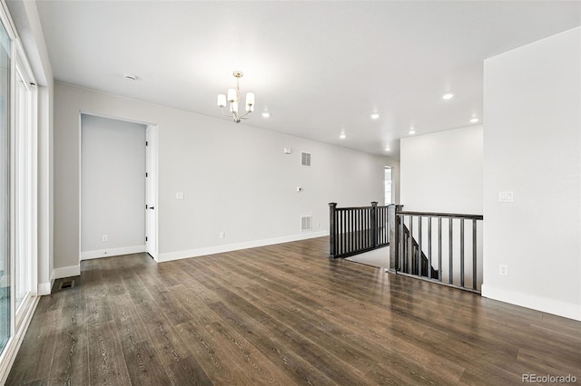 spare room featuring a chandelier, wood finished floors, recessed lighting, and baseboards