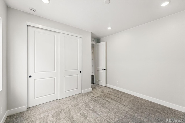 unfurnished bedroom with carpet flooring, recessed lighting, baseboards, and a closet