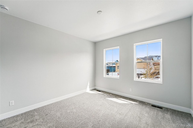 carpeted empty room with baseboards and a smoke detector