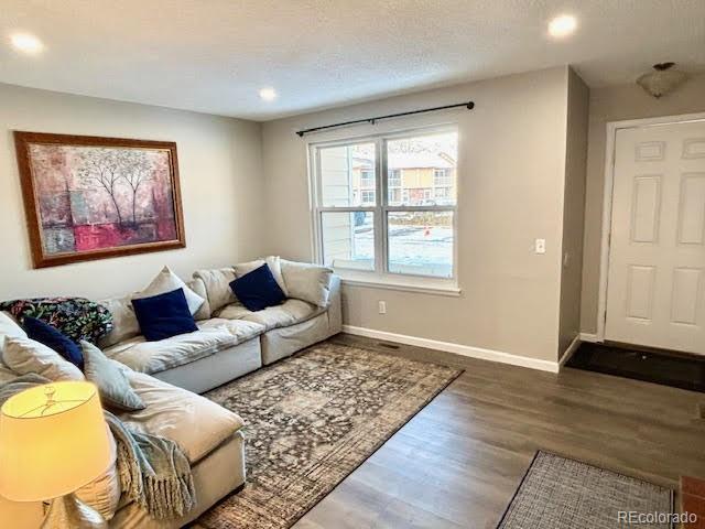 living room with dark hardwood / wood-style floors and a textured ceiling