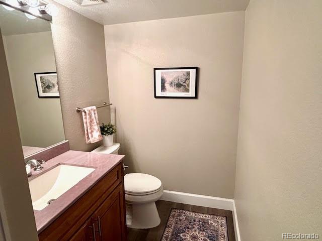 bathroom featuring hardwood / wood-style flooring, vanity, and toilet