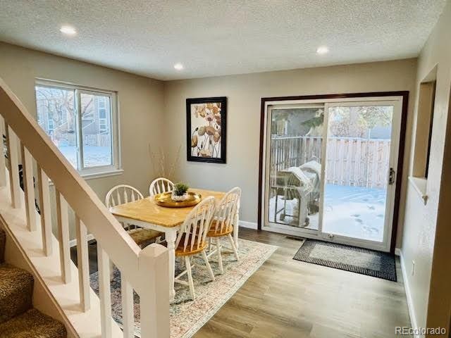 dining space with light hardwood / wood-style flooring and a textured ceiling