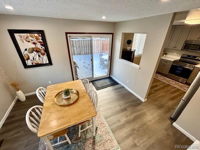 dining room with dark wood-type flooring and a textured ceiling