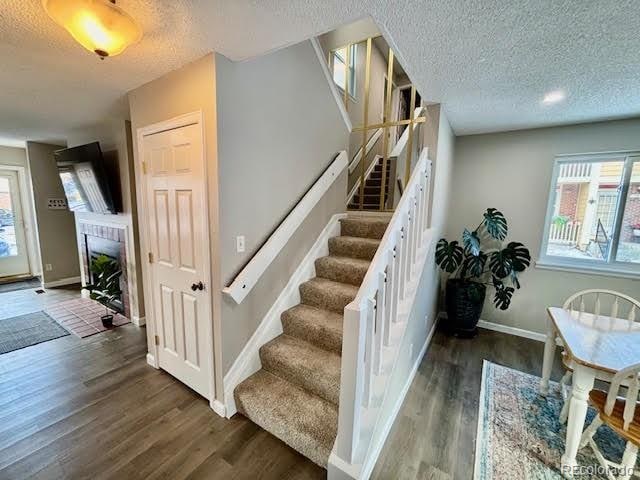 staircase with hardwood / wood-style flooring and a textured ceiling