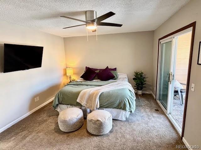 carpeted bedroom with ceiling fan and a textured ceiling